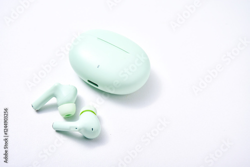 True wireless stereo (TWS) pastel green isolated white background, one type of audio output device that can produce sound without cables