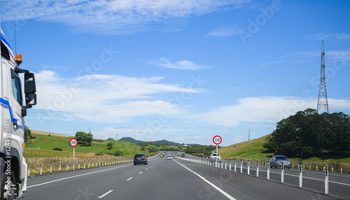Obraz na płótnie Truck driving on Waikato Expressway. 110 km/h road speed signs by the side of motorway. New Zealand. w salonie