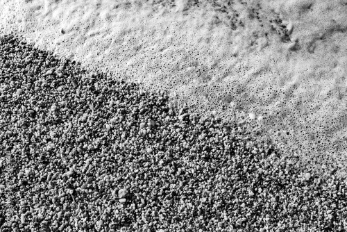 Pebbles on the beach washed by waves, at Mitchell Rocks, Otago Region, New Zealand photo