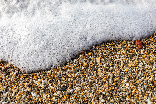 Pebbles on the beach washed by waves, at Mitchell Rocks, Otago Region, New Zealand photo