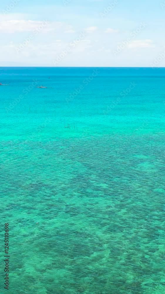 Sea surface with clear turquoise waters. Tropical coral reefs under blue sky and clouds. Cebu, Philippines. Vertical view. Sea surface with clear turquoise waters. Tropical coral reefs under blue sky and clouds. Cebu, Philippines. Vertical view.