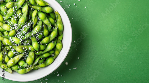 Wallpaper Mural Steamed edamame in white bowl with sea salt on green background Torontodigital.ca