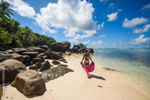 Woman with sarong walking on a beach, Secyhelles photo