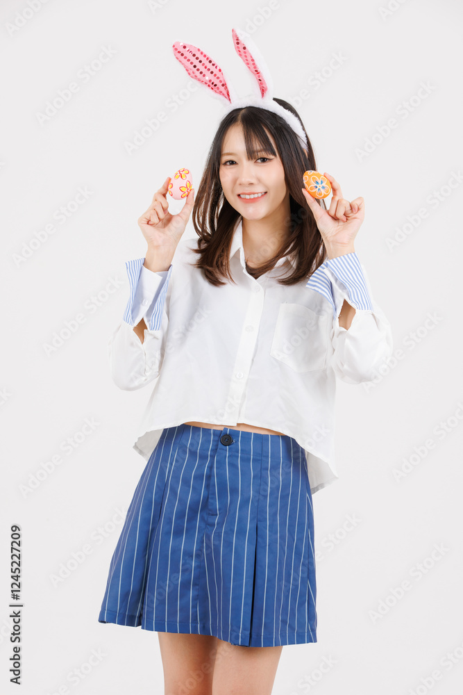 Portrait of happy asian young pretty woman wearing casual clothes bunny rabbit ears, teenager smiling funny holding colorful easter egg pose looking at camera on white background, Celebrate concept Portrait of happy asian young pretty woman wearing casual clothes bunny rabbit ears, teenager smiling funny holding colorful easter egg pose looking at camera on white background, Celebrate concept