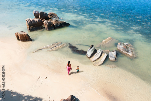 Aerial view of mother with baby child walking on a tropical beach, Praslin island, Seychelles photo