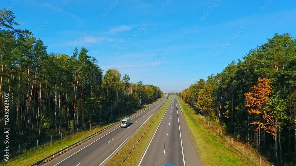 4k aerial video of car driving on highway through forest under clear blue sky 4k aerial video of car driving on highway through forest under clear blue sky
