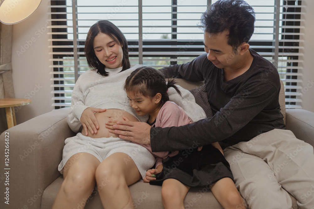 lovely family spend time together in their house, a pregnant mother sits on the couch with her husband and daughter enjoying a happy time together on a weekend lovely family spend time together in their house, a pregnant mother sits on the couch with her husband and daughter enjoying a happy time together on a weekend