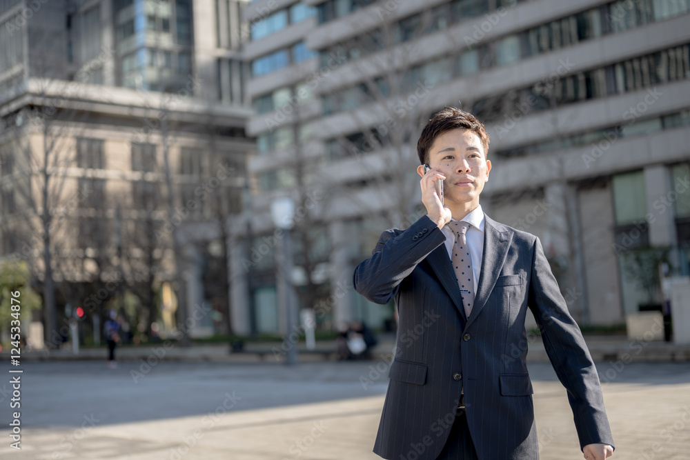 都会で電話するビジネスマン 都会で電話するビジネスマン