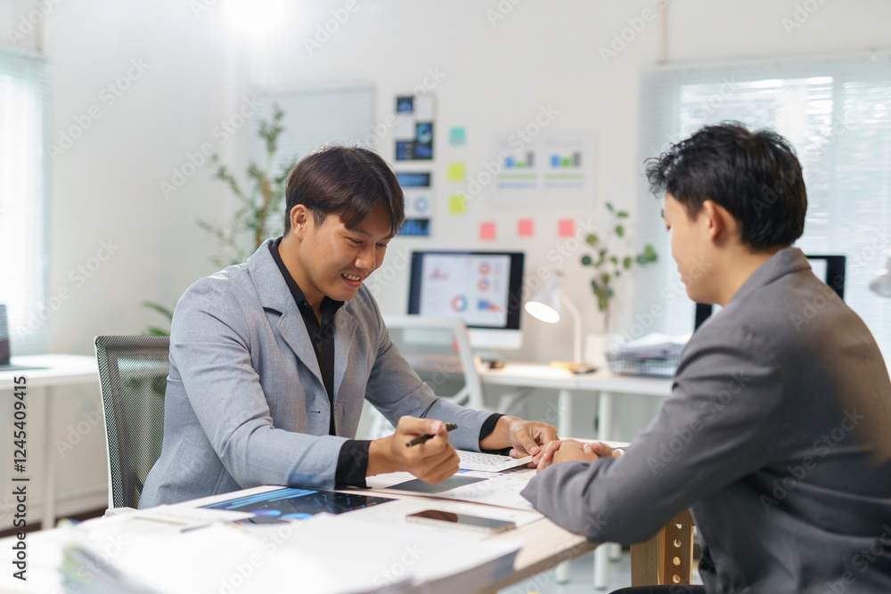Asian businessmen discussing and analyzing data in office meeting Asian businessmen discussing and analyzing data in office meeting