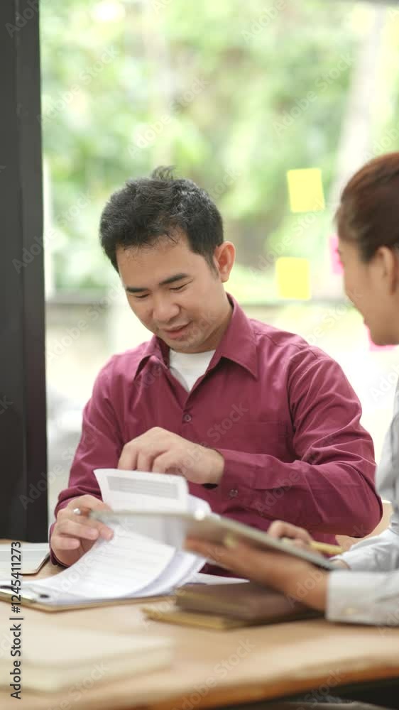 Male and female business people working in finance in an office. Male and female business people working in finance in an office.