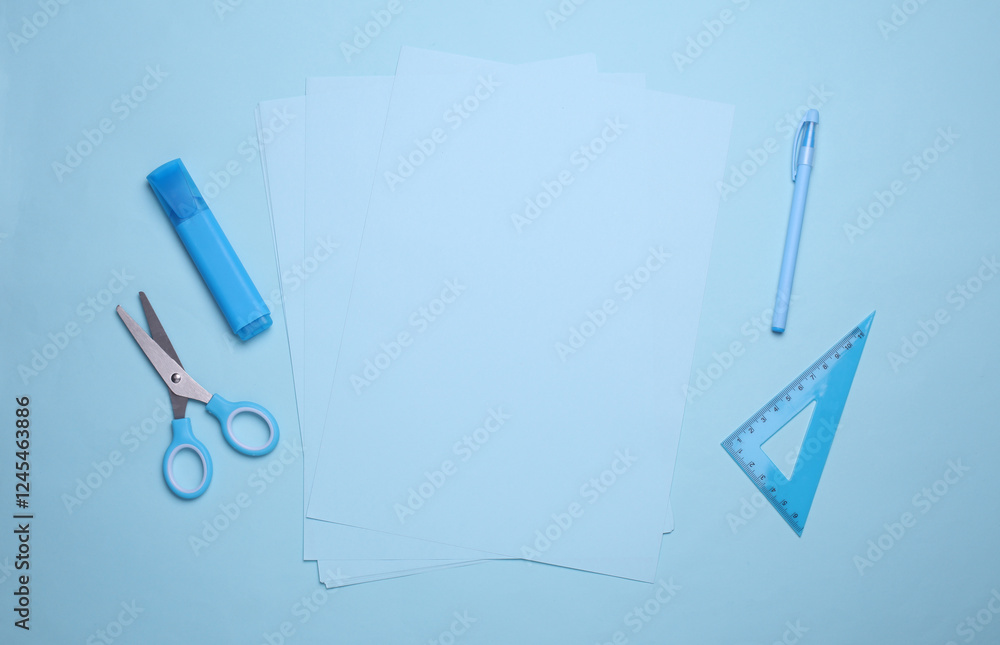 Blue sheets of paper with school stationery on blue background. Monochrome photography. Flat lay. Creative layout Blue sheets of paper with school stationery on blue background. Monochrome photography. Flat lay. Creative layout