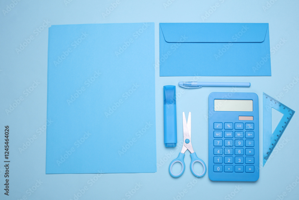 Blue sheets of paper with school stationery on blue background. Monochrome photography. Flat lay. Creative layout Blue sheets of paper with school stationery on blue background. Monochrome photography. Flat lay. Creative layout