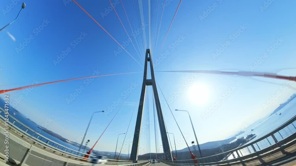 Cars Navigating a Modern Cable-Stayed Bridge Under a Clear Blue Sky. Cars Navigating a Modern Cable-Stayed Bridge Under a Clear Blue Sky.