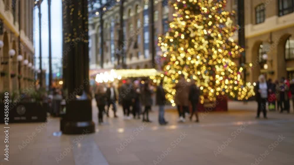 People walking in defocused london street with christmas decorations and festive lights in winter creating a bokeh effect