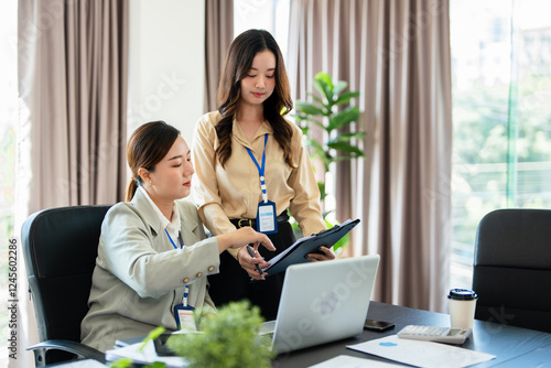 Foto Confident mature business professional woman talking to younger female colleague at office table, speaking, gesturing, teaching, explaining work tasks