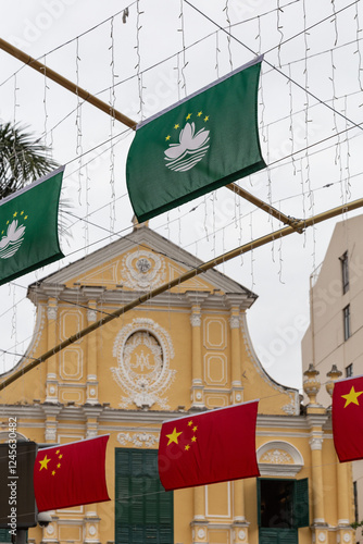 Macau's green flag hanging from street decorations with church behind photo