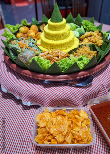Traditional dish named Nasi Tumpeng, yellow rice cone shape with various side dish around. Usually served to celebrate birthdays or anniversary and formal events in Indonesia.