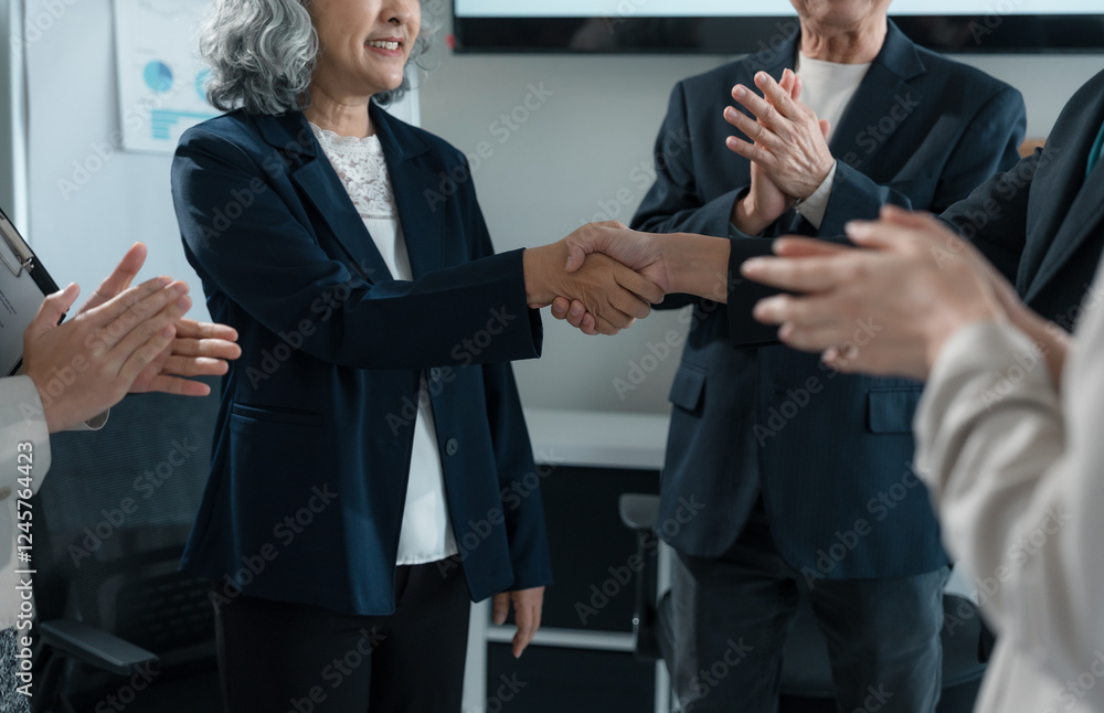 Two businesswomen shaking hands after successfully closing a deal, with colleagues applauding in the background of a modern office, celebrating teamwork and achievement Two businesswomen shaking hands after successfully closing a deal, with colleagues applauding in the background of a modern office, celebrating teamwork and achievement