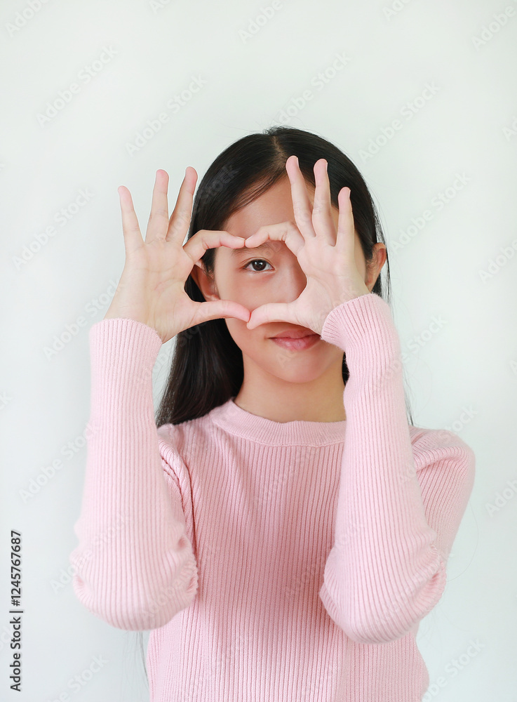 Asian girl preteen making heart figure or love sign by fingers at his eye on white. Asian girl preteen making heart figure or love sign by fingers at his eye on white.