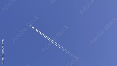 Wallpaper Mural travel dream,Airplane flying high in blue sky, leaving white contrails. Aircraft soaring through clear atmosphere, trailing condensation. Jet traveling across open sky, forming vapor trail. Torontodigital.ca