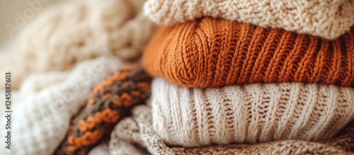 Warm Knitted Sweaters Pile in Earthy Tones Cozy Textured Background for Autumn Winter Season Copy Space for Seasonal Promotions photo