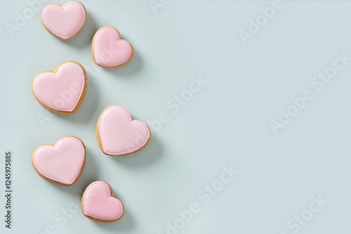 Obraz na płótnie Seamless pattern of heart shaped cookies with pink glaze on blue background. Valentines day wallpaper or greeting card. w salonie