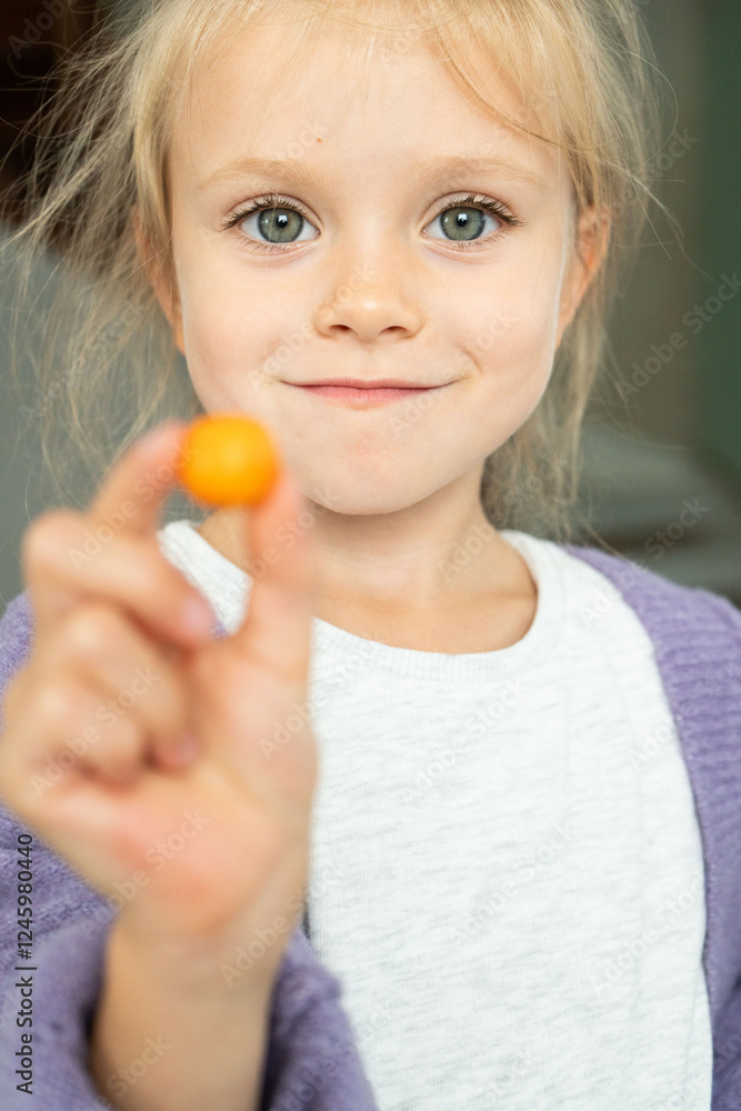 A little girl is happily holding a colorful lollipop in her tiny hand, showcasing her innocent joy and bright smile to the world A little girl is happily holding a colorful lollipop in her tiny hand, showcasing her innocent joy and bright smile to the world