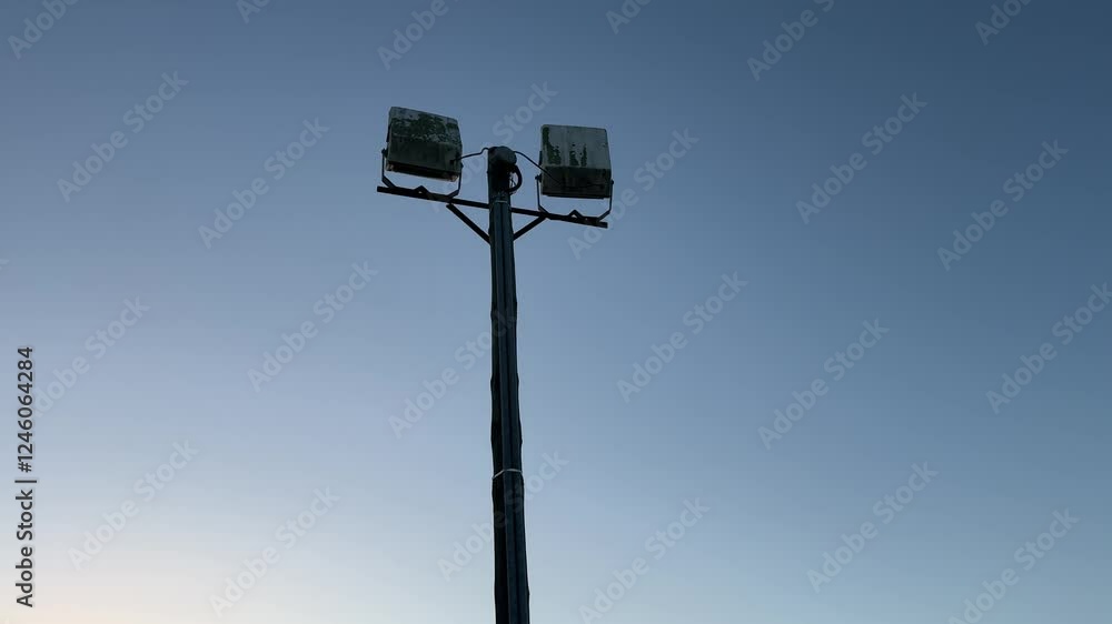 Sports field floodlight or lamp at sunset in silhouette, on a field in Cape Town. Sports field floodlight or lamp at sunset in silhouette, on a field in Cape Town.