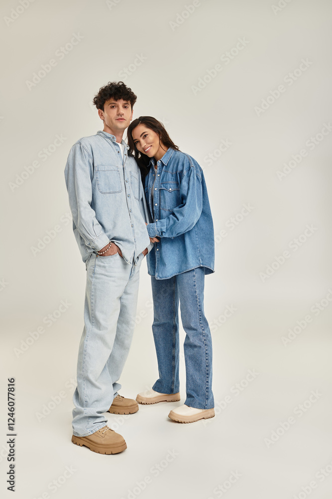 Stylish young couple showcasing trendy denim fashion in a minimalist studio setting Stylish young couple showcasing trendy denim fashion in a minimalist studio setting