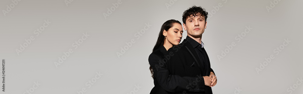 Stylish young couple showcases modern fashion against simple backdrop Stylish young couple showcases modern fashion against simple backdrop