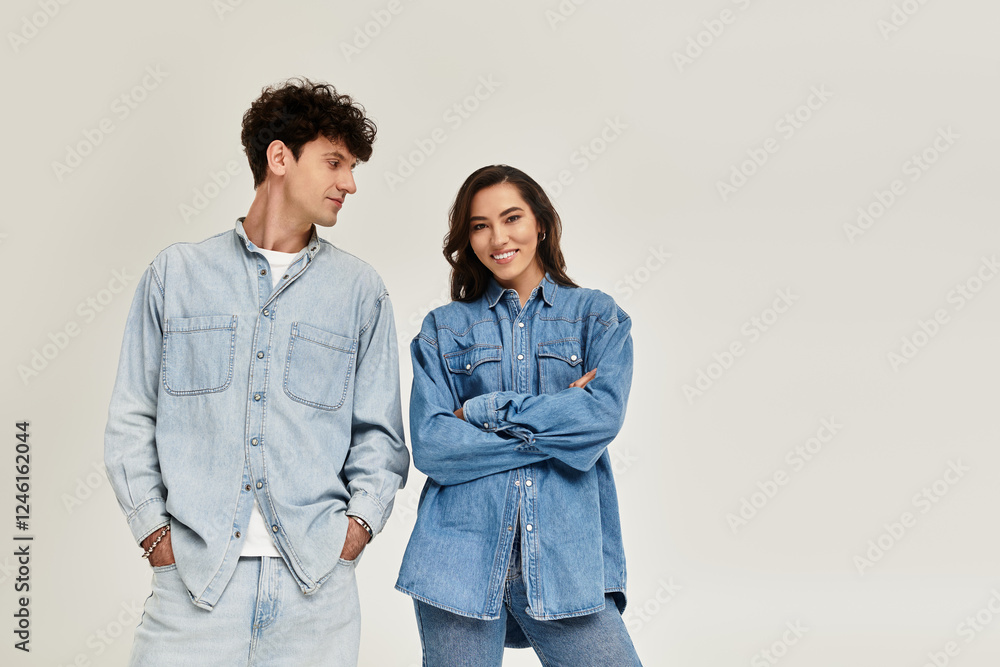 Stylish young couple showcasing trendy denim fashion in a modern studio setting Stylish young couple showcasing trendy denim fashion in a modern studio setting