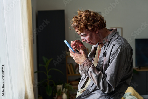 Fotografija Male Zombie Trying To Use Smartphone