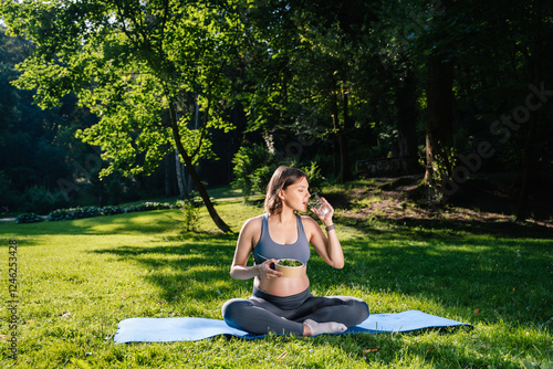 Pregnant young woman having her lunch after yoga and looking peaceful photo