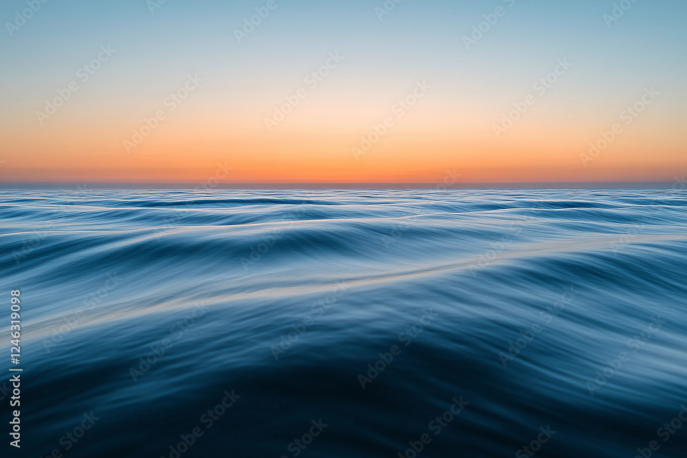 Obraz premium Sunset over calm ocean waters creates a serene atmosphere with vibrant colors on the horizon