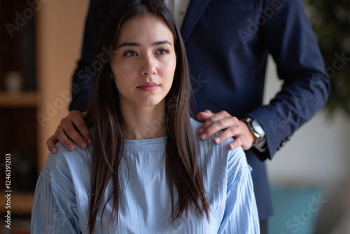 woman seated man standing behind her hand on shoulder supportive gesture