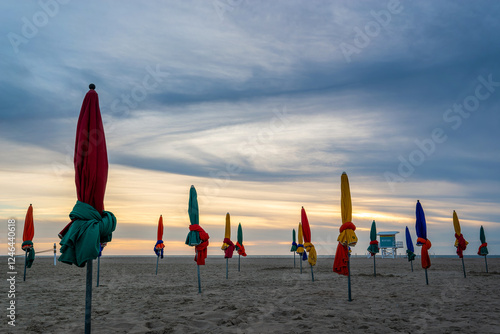 Obraz na płótnie Beach of Deauville at sunset, famous vintage parasols and lifeguard station tower, in Normandy, France w salonie