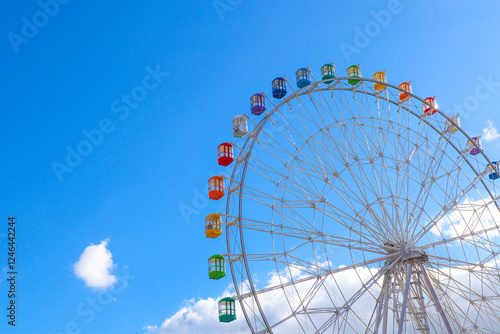 Colourful ferris wheel against a blue sky.