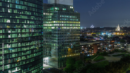 Aerial night timelapse of modern skyscrapers and towers in Brussels with glass facades and glowing windows. Belgium