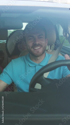 A man is comfortably driving a vehicle while a passenger enjoys sitting in the backseat