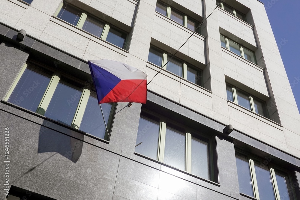 Czech national flag waving on modern building, shadow on wall
