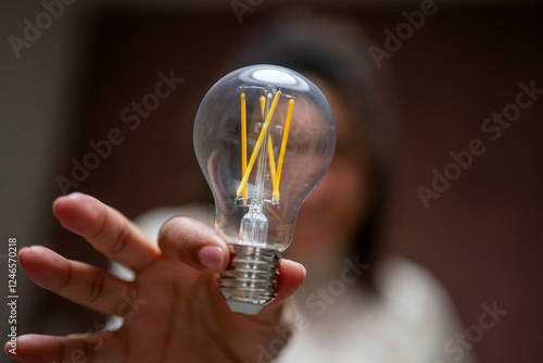 Woman holding a clear LED light bulb while blurred. Netherlands photo