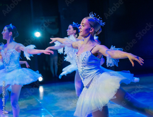 Ballet dancers in white tutus perform on stage in dramatic blue lighting. The Nutcracker, Bainbridge Island, USA