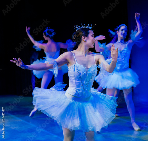 Ballet dancers in blue tutus performing gracefully on stage with spotlights. The Nutcracker, Bainbridge Island, USA photo