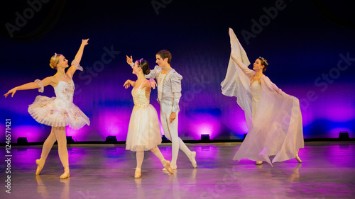 Ballet dancers in elegant costumes perform on a stage with vibrant lighting. The Nutcracker, Bainbridge Island, USA