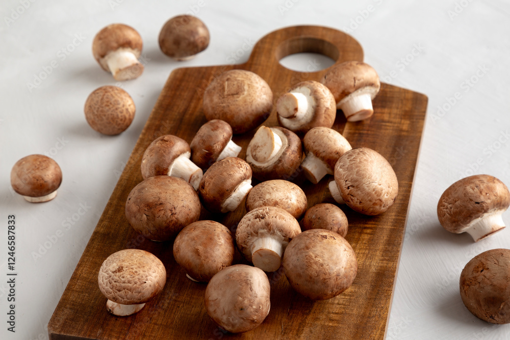 Raw Royal Brown Champignon on a wooden board, side view. Raw Royal Brown Champignon on a wooden board, side view.