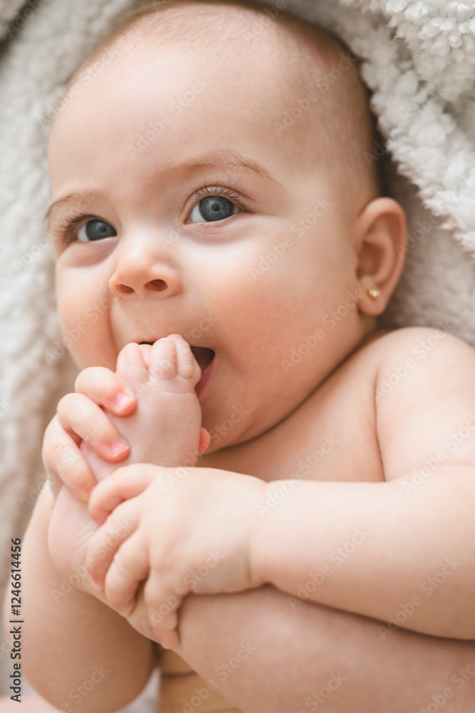 Laughing baby girl on white bedroom
