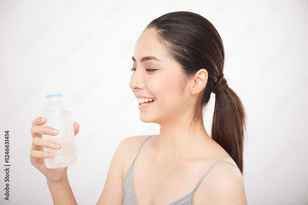 Asian girl hold the water bottle and smiling on white background Asian girl hold the water bottle and smiling on white background