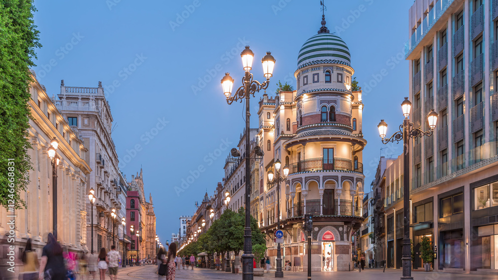 Fototapeta premium Illuminated Adriatica building on Avenida de la Constitucion at night, Seville, Spain