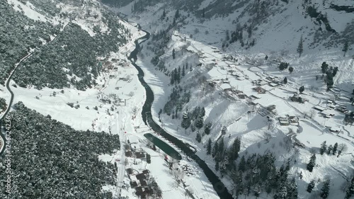 Aerial drone footage of a beautiful snow-covered landscape and scenic river in swat, pakistan 