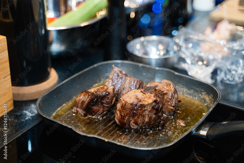 small pieces of beef steak are fried in a frying pan